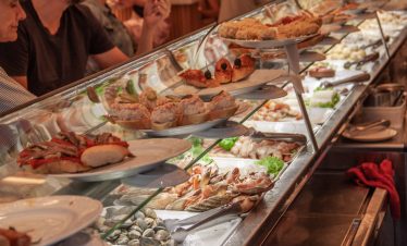 Interior of a traditional Spanish tapas bar with wine bottles on shelves. Pinchos