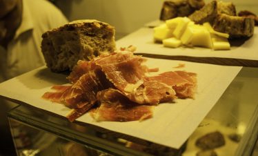 Plate of assorted Galician tapas with local cheese, chorizo, and olives.